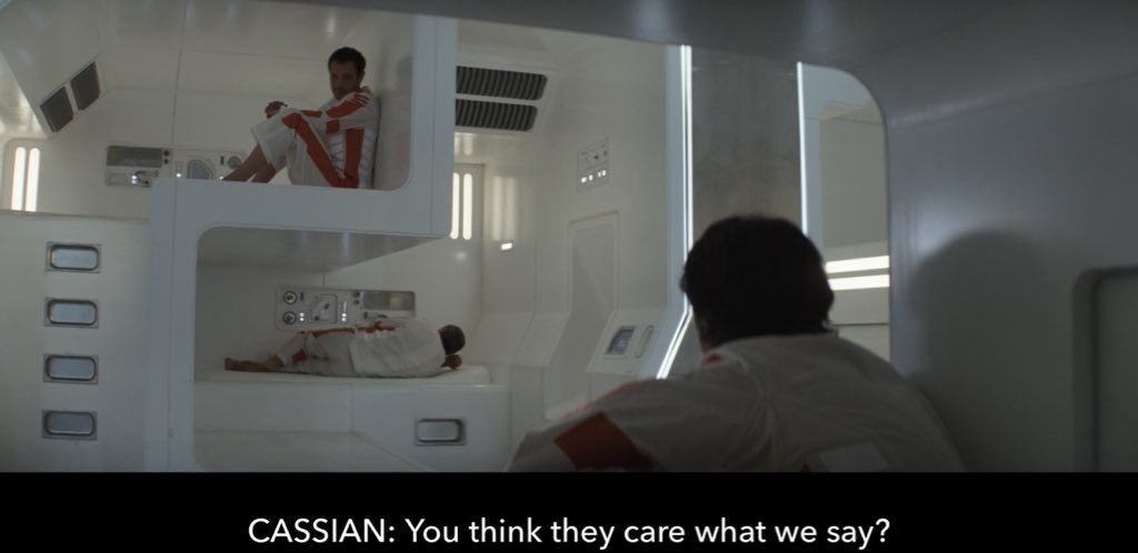(scene in the dysopian interior of an Imperial prison labor colony from the Star Wars universe. It's Stormtrooper white, inorganically lit, and limited to 90, 45 and 30 degree angles, all ominously rounded with a stark, Modernist curve)

CASSIAN ANDOR: You think they care what we say?